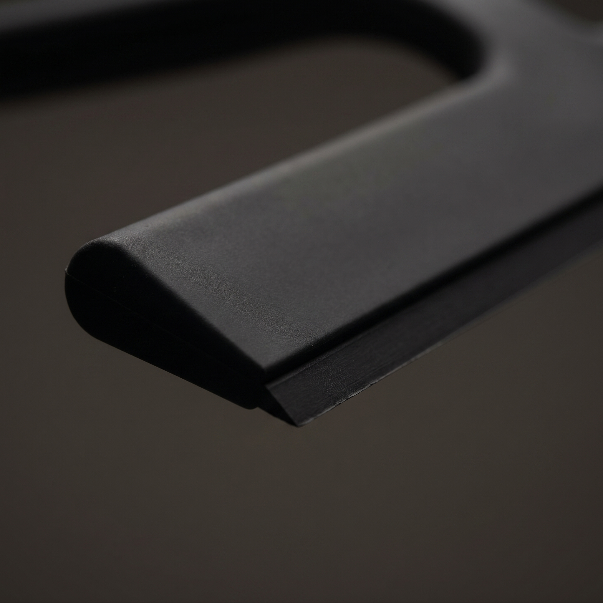 Close-up of the soft silicone blade on the matte black shower squeegee