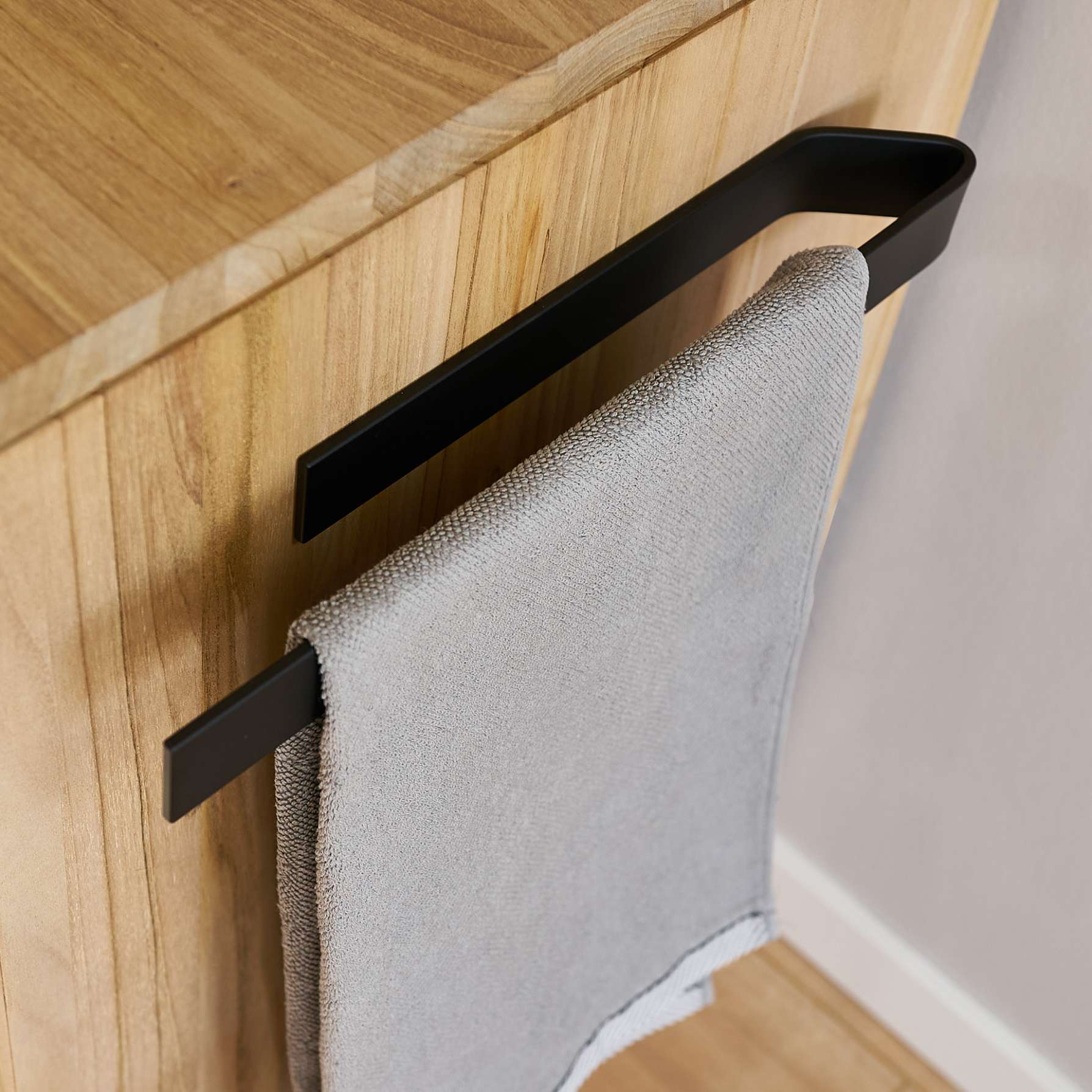 Matte Black drill-free adhesive towel bar holding a towel — black lifestyle 40cm